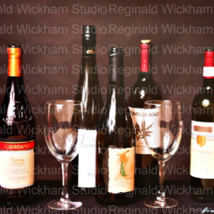 Beautifully edited photograph of wine bottles and glasses arranged on tabletop