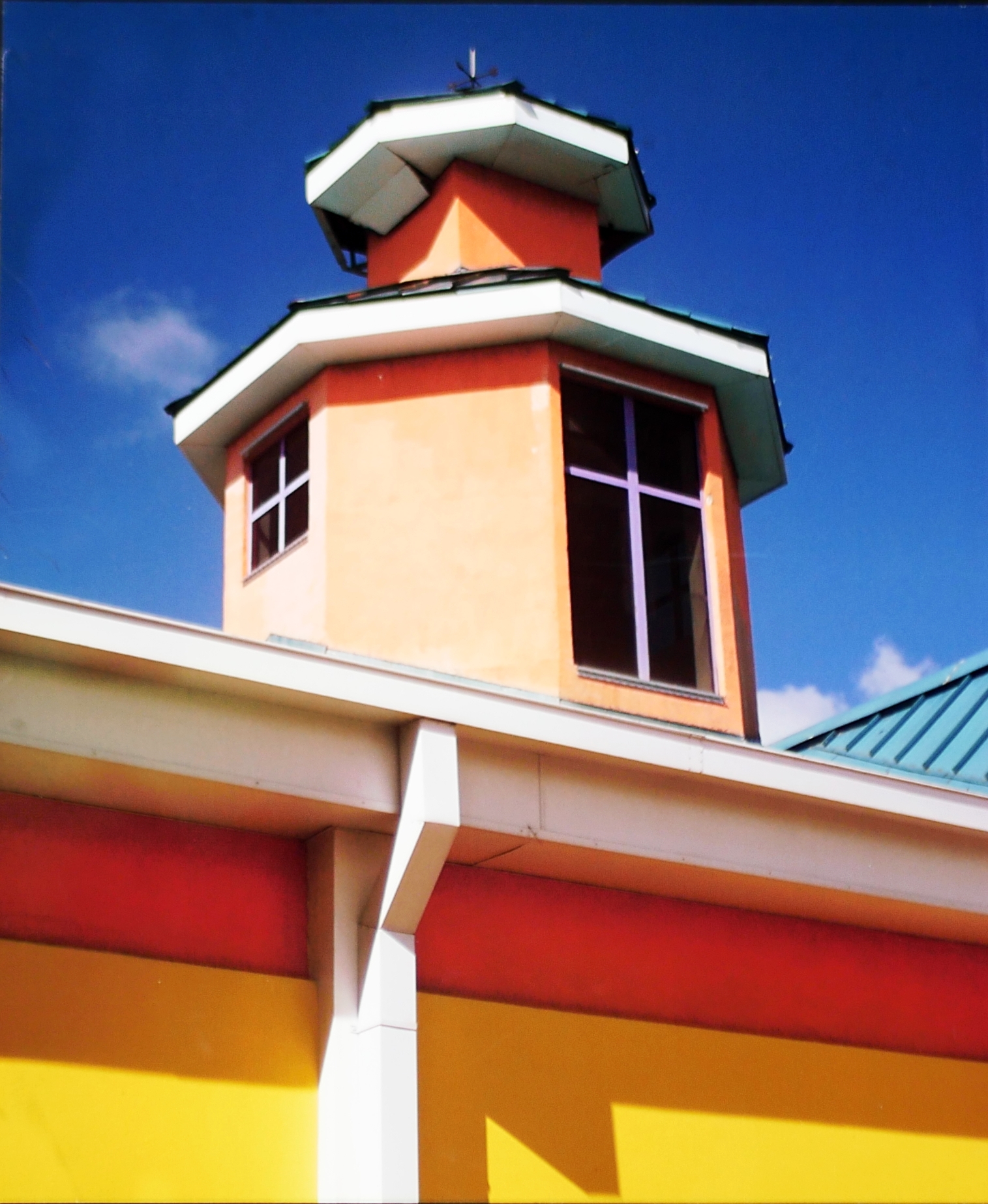 Original artistic photograph of a steeple. Picture of ocean town steeple of small building. Pink and Yellow sided short tower